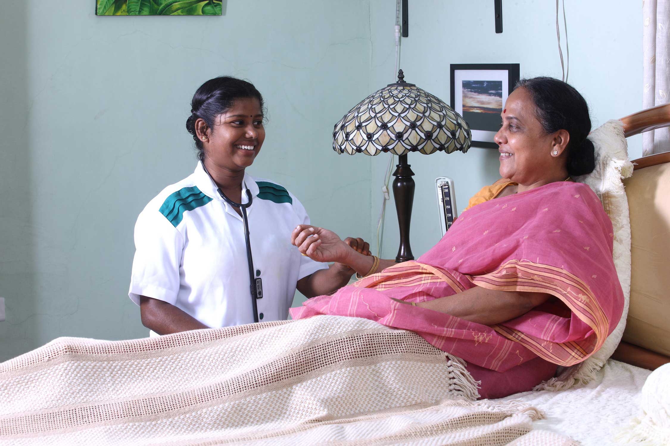 Indian nurse attending to a patient at home